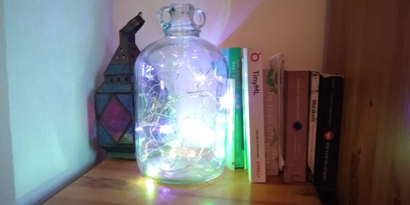 neopixel lights in a jar on a wooden side table