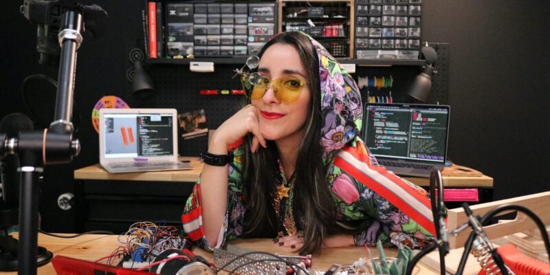 estefannie at her desk in colourful hoodie