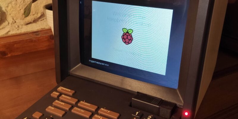 A Minitel Laptop that has been modified to run on Raspberry Pi. The screen shows the splash screen for Raspberry Pi OS