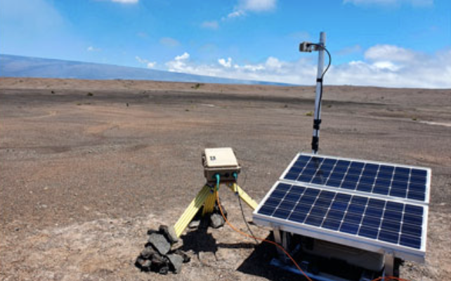volcanoe photography rig sat next to solar panel on desert like terrain with a blue sky