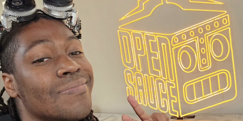 jorvon posing in front of an LED Open Sauce sign