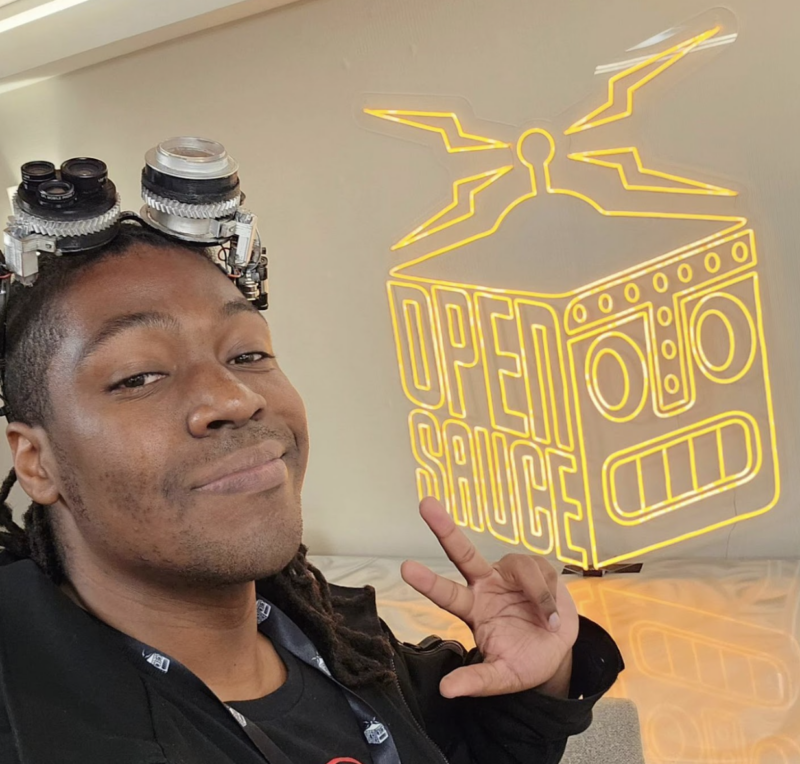 jorvon posing in front of an LED Open Sauce sign