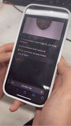 the maker's phone in his hands displaying the cooking monitor app on the screen