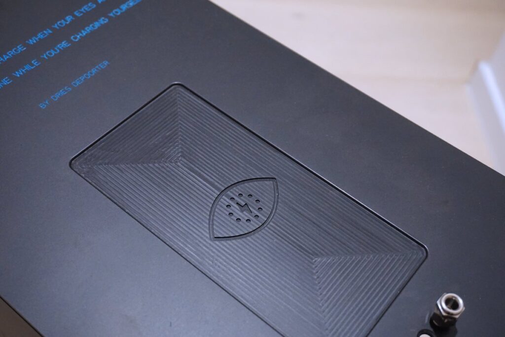 A close-up of the charging pad on the black box next to the reclining chair