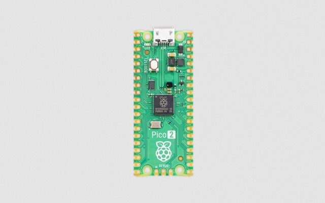 The image shows a Raspberry Pi Pico 2, a small, rectangular microcontroller development board designed by the Raspberry Pi Foundation. This board is similar in appearance to the Raspberry Pi Pico, but it includes wireless connectivity features, as denoted by the "W" in its name.