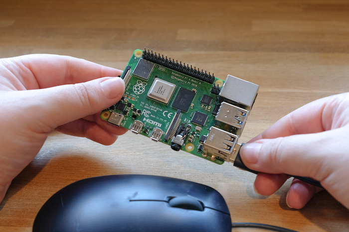 Plugging a mouse into a Raspberry Pi.